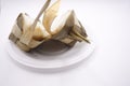 a ketupat that has been halved on a plastic plate, photo taken from the side at 45 degrees