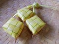Ketupat on woven bamboo background. Ketupat are rice cake wrapped in woven young coconut leaves