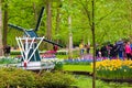 Keukenhof, Lisse, Netherlands - Apr 28th 2019: Famous Keukenhof gardens with windmill, colorful tulip flowers and visitors. Tulips