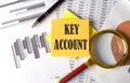 KEY ACCOUNT text on a sticky on the graph background with pen and magnifier Royalty Free Stock Photo