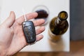 Key of car and a bottle of wine in a background - blured background