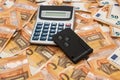 Key for car and calculator on background of Euro bills Royalty Free Stock Photo