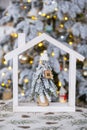 Key on Christmas tree and tiny house on cozy home with Christmas decor on table of festive white kitchen. Gift for New Year.