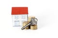 Key and coins stack and paper house on white background