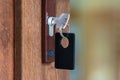 Key with key fob in the keyhole of a closed door