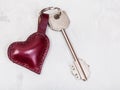 Key with heart shape keychain on concrete plate Royalty Free Stock Photo