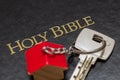 Key with house shaped key chain on bible Royalty Free Stock Photo