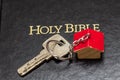 Key with house shaped key chain on bible Royalty Free Stock Photo