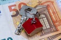 Key with house shaped key chain on euro banknotes Royalty Free Stock Photo