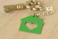 Key with a key chain in shape of a green house - Love for home a Royalty Free Stock Photo