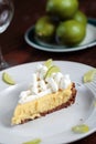 Key Lime Pie on wood table with limes Royalty Free Stock Photo