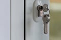 The key in the mortise lock of a white plastic door. Keyhole opening. The concept of forgetfulness and distraction of the landlord Royalty Free Stock Photo