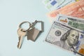 Key for a new house or apartment and currency paper banknotes euro dollars bills. Royalty Free Stock Photo