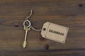 Key and a note on a wooden table with text - Grammar Royalty Free Stock Photo