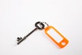 Key with orange key ring tag on white background