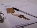 Key with paperwork and pen for property medium shot