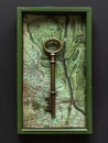 Key is placed inside shadowbox against map Royalty Free Stock Photo