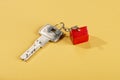 Key and fob with red house on yellow background Royalty Free Stock Photo