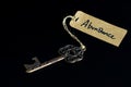 Key to abundant life concept - Old key with abundance tag isolated on black background Royalty Free Stock Photo