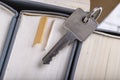 The key to the door in a single-family house laid on the spines of books. Metal key for patent lock Royalty Free Stock Photo