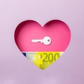 The key to the door and the two hundred euro banknote are in a pink heart on a purple background. Minimal concept of money, love Royalty Free Stock Photo