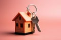 Key to a house, attached to a keychain on pink background. Concept buying a new house and the real estate property