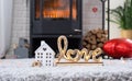 Key to house with keychain against background of fireplace stove with fire and firewood in Valentine decor, love home. Moving to