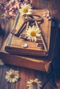 Key to knowledge concept. Old keys on a vintage book with flowers on wooden background Royalty Free Stock Photo