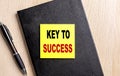 KEY TO SUCCESS text on a sticky on black notebook with pen Royalty Free Stock Photo