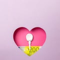 The key and the two hundred euro banknote are in a pink heart on a purple background. Minimal concept of money, love and security Royalty Free Stock Photo