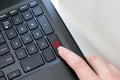 Keyboard corner of a black laptop with a female finger clicking on a fake news button. The concept of spreading false news Royalty Free Stock Photo