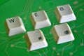 Keyboard keys form the word WEB on green electric circuit in the background Royalty Free Stock Photo