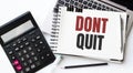 Keyboard of laptop, calcualtor, pencil and notepad with text DONT QUIT on the white background