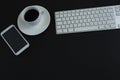 Keyboard, mobile phone and black coffee on black background Royalty Free Stock Photo