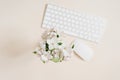 Keyboard and mouse and white apple flowers in a vase out of focus on a beige table. Layout and design concept. Flat lay Royalty Free Stock Photo