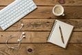 Keyboard, notepad, earphones on rustic wooden table Royalty Free Stock Photo