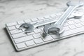 Keyboard and spanners on marble table. Concept of technical support