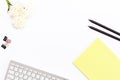 Keyboard, a yellow pad, two black pencil, chrysanthemum flower and clips for paper on white background. Flat lay. Royalty Free Stock Photo