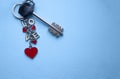 Keychain with red hearts and white letters LOVE with a metallic key on a blue background with copy space top view Royalty Free Stock Photo