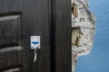 The keychain sits in the door lock as you open or close the entry or exit doors near an old broken wall in need of repair and Royalty Free Stock Photo