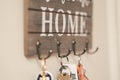 keys hanging on wooden and metal key hook with welcome home message Royalty Free Stock Photo