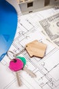 Keys with home shape, currencies dollar and house under construction on electrical construction drawings. Building or buying home Royalty Free Stock Photo