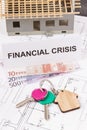 Keys with home shape, euro and inscription financial crisis on construction drawings. Real estate crisis concept. Small house Royalty Free Stock Photo