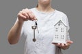 Keys from house concept. woman holds small house and keys in her hand. Buy real estate. Real estate services for buying your home Royalty Free Stock Photo