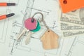 Keys with house shape, currencies dollar and electrical construction drawings with work tools. Building or buying home concept Royalty Free Stock Photo