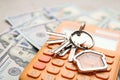 Keys with house trinket and calculator on money. Real estate agent service