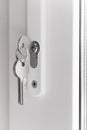 Keys in lock, white plastic door, window. Closeup Royalty Free Stock Photo