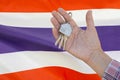Keys to the apartment in a female hand on background of flag Thailand