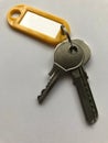 Keys with yellow key ring with blank tag. White background Royalty Free Stock Photo