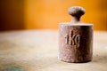 1 kg rusty weight in shallow focus. Old rusty measurement steel piece